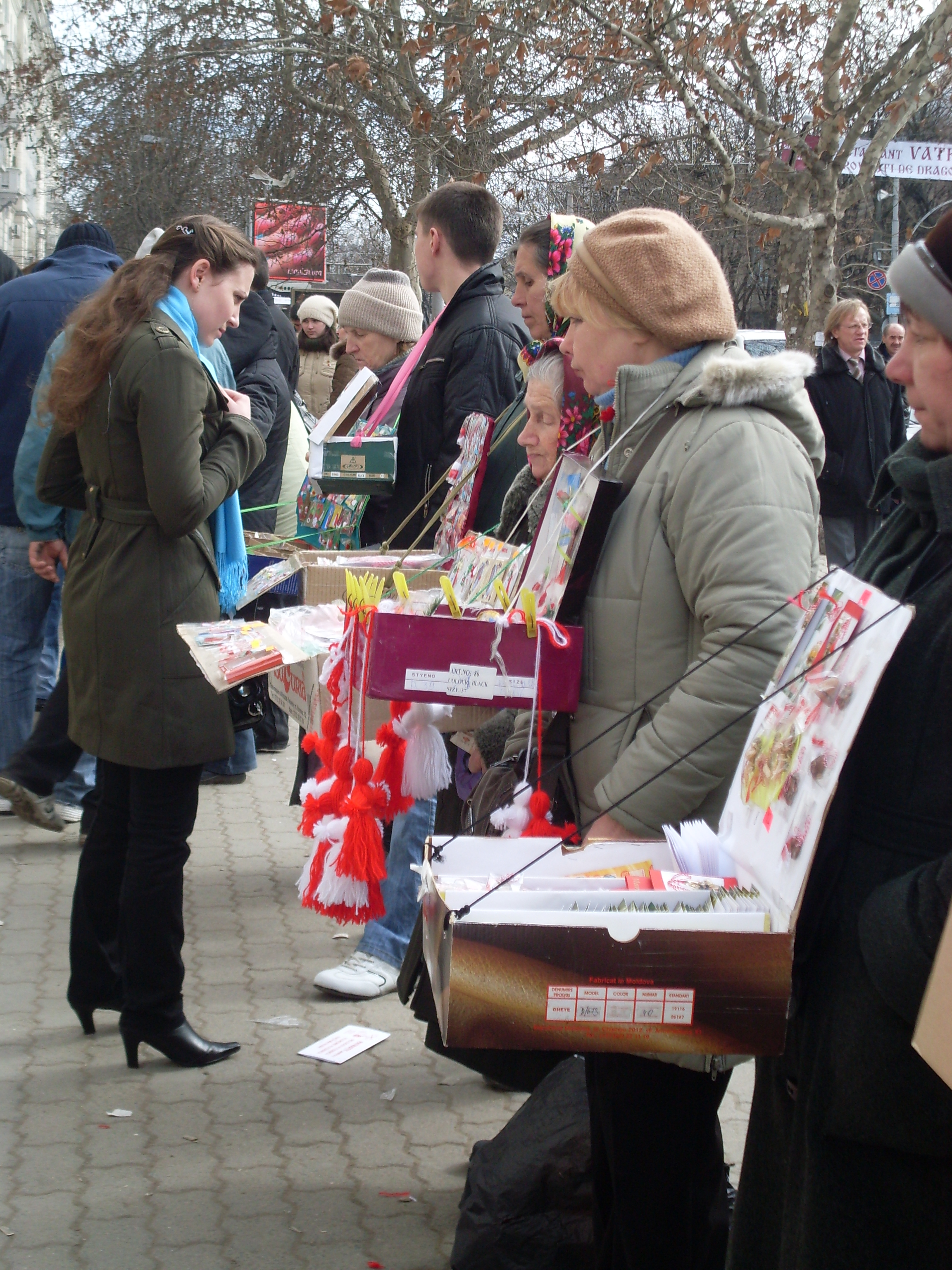 image of a line of Mărțișor sellers and a woman perusing their goods.