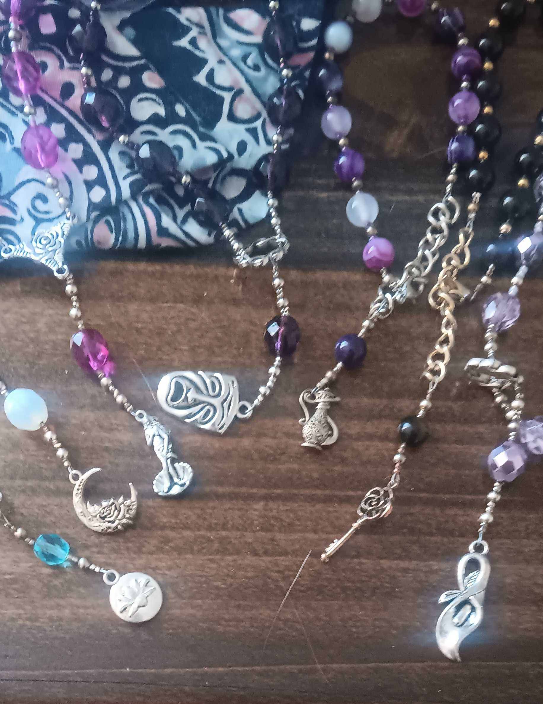 several sets of prayer beads on a wooden table
