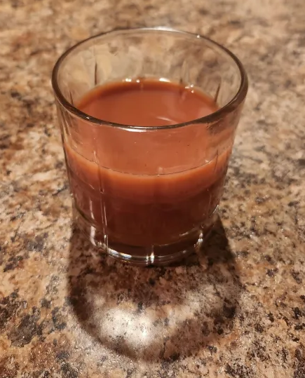 a glass of orange pomegranate spiced punch